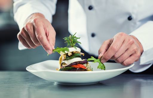 yacht chef finishing a dish