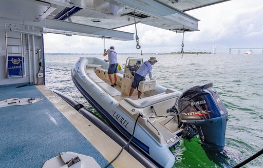 Yacht crew on superyacht launching yacht tender for use