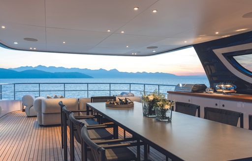 Alfresco dining set up with exterior lounge onboard Oasis 34M.