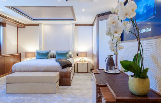 Cabin onboard Superyacht QUATTROELLE. Central berth with side tables and a flatscreen TV on starboard side.