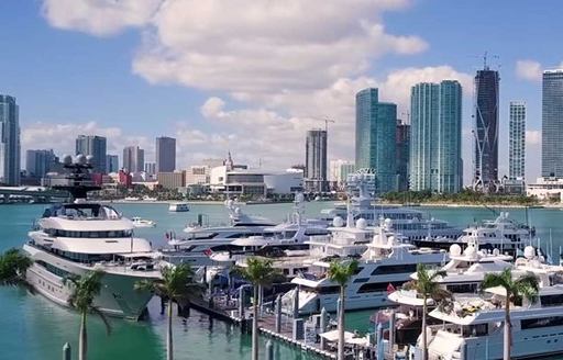 Overview of Yacht Haven Grande Miami at Island Gardens, motor yachts moored with Miami skyline in background 