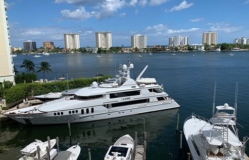 Close up view of superyachts moored at Boca Raton Resort & Club Marina – Boca Raton. Skyscrapers and sea in background