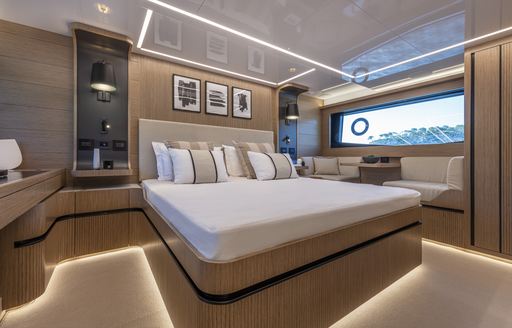 Master cabin onboard Pearl 62, central berth with wide window on far side