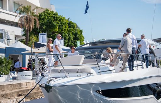 Visitors at the Cannes Yachting Festival standing on the bow of an attending yacht