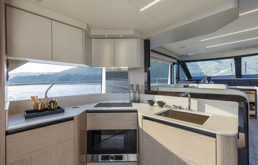 Galley onboard Absolute 50Fly, central oven appliance with sink to starboard, surrounded by wide windows