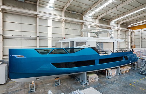 Blue hull of XSR 85 yacht in outfitting shed