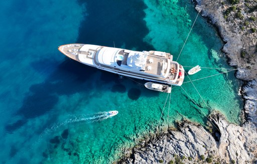 yacht on anchor with lines ashore