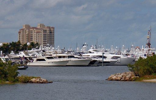 Rows of motor yachts moored at Palm Beach International Boat Show, with towering Palm Beach hotel overhead