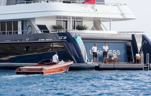 deck crew on transom with classic tender