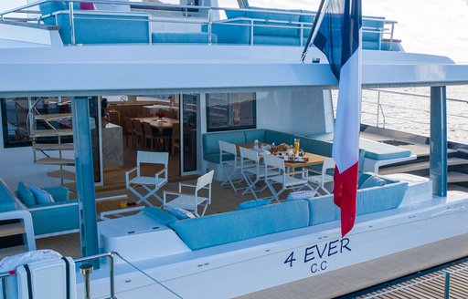 Aft view of Long Island 78 Power 4EVER, name visible at stern, with al fresco seating area sheltered by flybridge