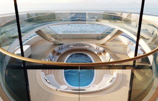 Elevated view onboard Feadship PURE, lookinf down through decks to swimming pool below.