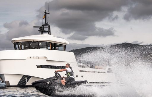 YXT 24 Evolution at sea with jetski speeding through foreground, overcast sky above