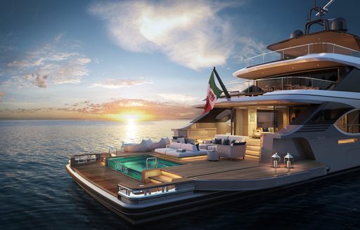 Swim platform of motor yacht as sunsets, with sofa and seating on deck and ambient lighting