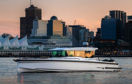 Chase boat on calm water with skyscrapers in background