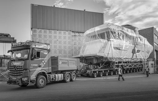 Side view of Numarine 26XP sitting on a trailer awaiting transit, surrounded by shipyard buildings