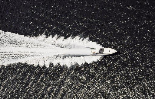 aerial greyscale shot motor yacht at speed