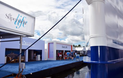 Exhibitor stands at Superyacht Village FLIBS, fronted by blue carpet