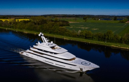 Overlooking Lurssen 'Project Hawaii' underway, surrounded by rolling hills in background.