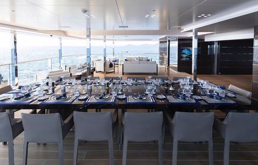 Dining option onboard superyacht BOLD, dining table and chairs overlooking views on aft deck.