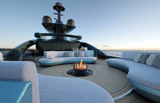 rendering of a fire pit surrounded by curved sofas on the sundeck of S702 model 