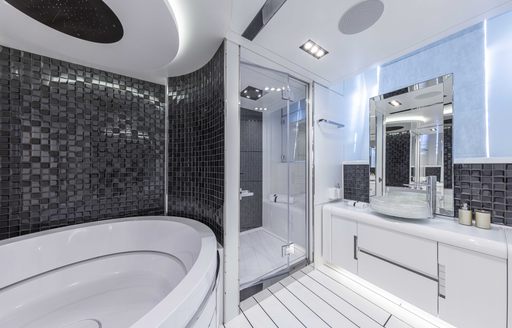 Bathroom onboard Pershing 140 'Touch Me', corner bath on port side with separate shower cubicle in centre and sink with large mirror to starboard