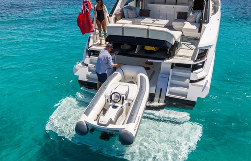 Sunseeker Superhawk 55 for sale at Fort Lauderdale International Boat Show, image is mid aerial shot over transom where tender is being manouvered into storage