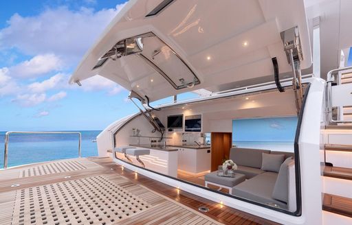 rendering of teak swim platform on the aft deck of the FD87 Skyline with door open revealing seating and bar area