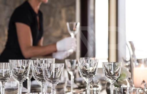 superyacht stewardess setting table and glassware