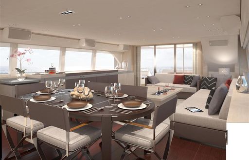 Overview of the main salon onboard O NOSO UNO, with formal dining area in the foreground and lounge area in the background.