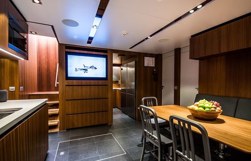 Inside galley onboard YXT 24 Evolution, with dining table on starboard side and kitchen facilities to port