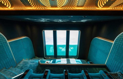 Teal themed interior cinema with plush raised seating onboard motor yacht KISMET