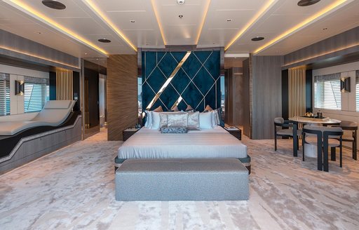 Large cabin on superyacht TATIANA with bed and table and chairs visible