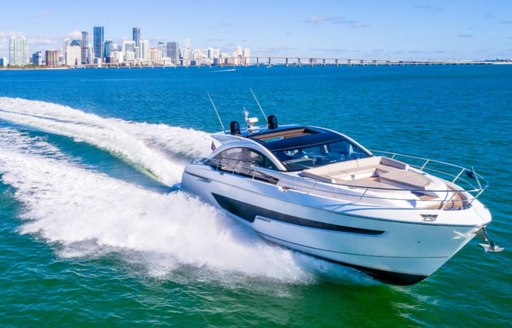 Fairline Targa 65 GT underway, with skyscrapers in far distance.