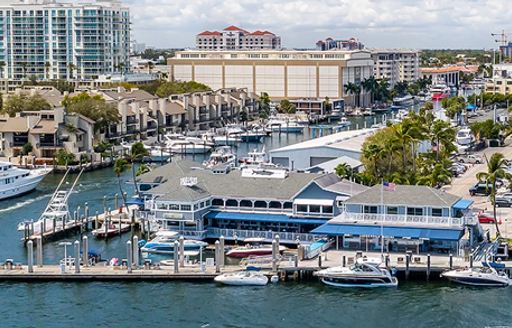 Entrance to Lauderdale Marina – Fort Lauderdale, multiple motor yachts moored, with Fort Lauderdale infrastructure in background