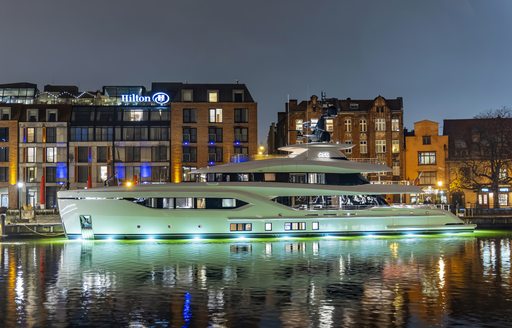 ACE C144S yacht shown at night with city scape in background, port side profile shown