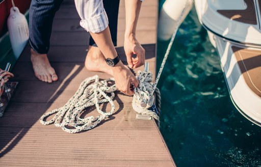 yachtsman tying sea knot while mooring the Yacht