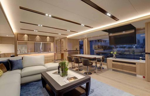 Horizon FD80 interiors, overlooking the main salon with L shaped sofa and coffee table, drop down TV from ceiling and wide windows.