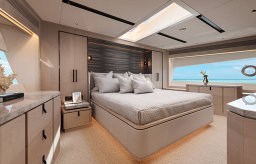 Master cabin onboard Horizon FD80 Sweet Caroline, central berth facing forward with wide window in the background.