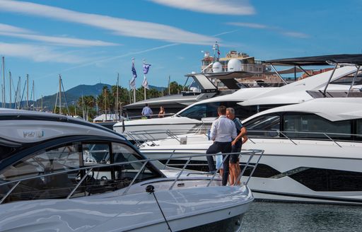 Two men standing on the bow of a superyacht in Vieux Port marina