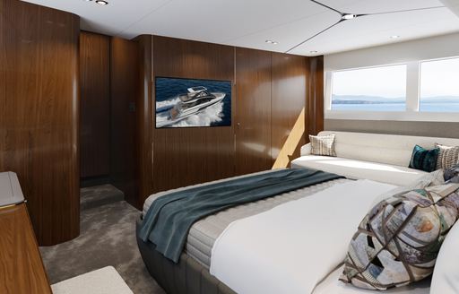 Master cabin onboard the Fairline Squadron 58. Central berth facing forward with wide window on starboard side and a wall mounted flat screen TV.