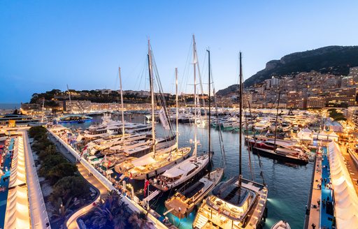 sailing yachts on display Monaco Yacht Show at dusk