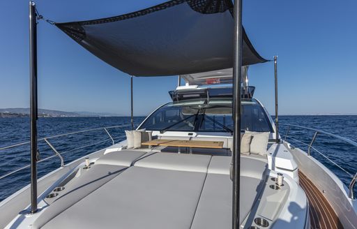 Overview of Pearl 62 foredeck, large sunpads with bimini overhead for shade, surrounded by sea