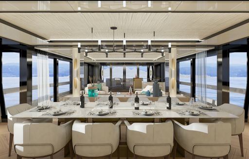 Interior dining area onboard Arcadia A115, central table adorned with 10 white chairs, surrounded by wide expanse of windows