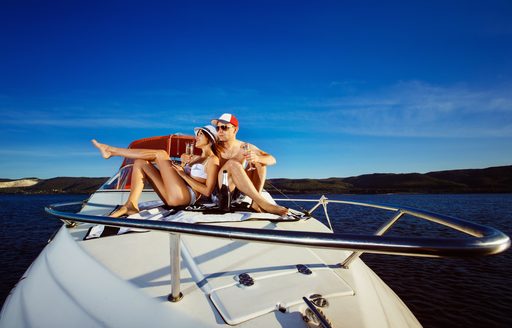 Couple sitting on yacht with beautiful blue sky behind