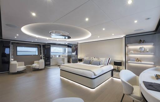 Master cabin onboard Mangusta Oceano 50. Central berth with dressing table at forefront and small lounge area to port.