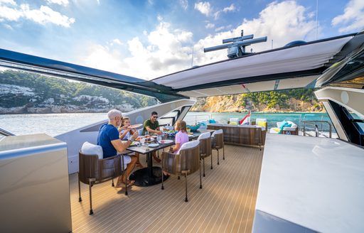 Family eating meal at table on deck of Sunseeker 90 Ocean