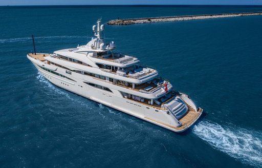 CRN superyacht MIMTEE shown in aerial view, running shot, port quarter deck and along port side profile, blue sea, bright day