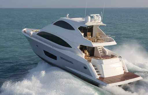 Aft view of Viking 75 MY underway, with sunloungers on bridge deck, surrounded by sea.