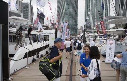 Visitors at the Miami International Boat Show talking on the pontoons