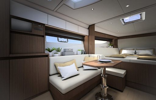 Overview of the cabin onboard the Bavaria SR33. Berth visible in background with small dining area in foreground.